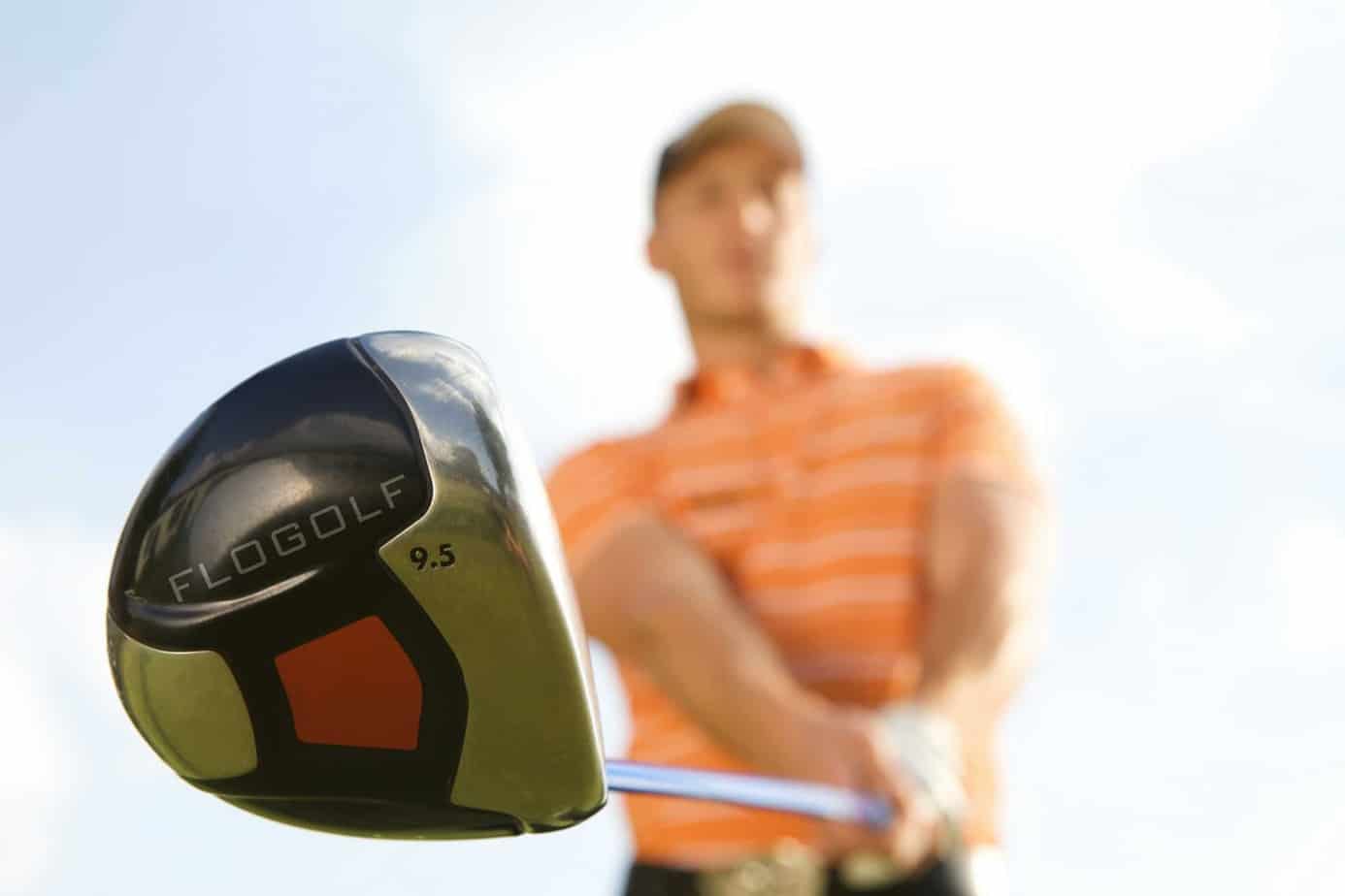 Een man slaat een golfbal met een golfclub.