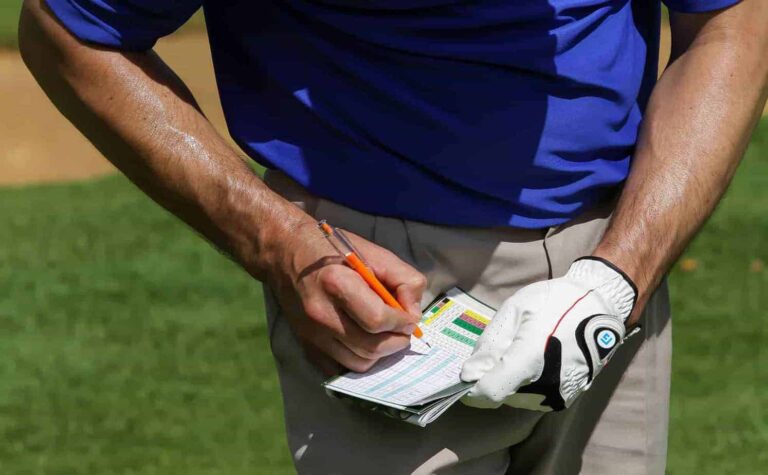 Een man die een golfscorekaart in zijn hand houdt en het Stableford-formaat speelt om het plezier van zijn spel te vergroten.